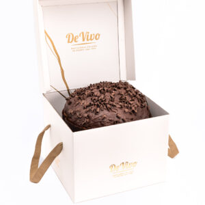 Panettone de Chocolate Pasticceria De Vivo 1kg dentro de su caja premium blanca abierta, con cobertura de chocolate y virutas en la superficie, fotografía profesional en fondo blanco.