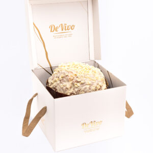 Panettone de Limoncello Pasticceria De Vivo 1,2kg dentro de su caja premium blanca abierta, con cobertura clara y virutas de chocolate blanco, fotografía profesional en fondo blanco.