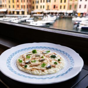 Risotto cremoso con Arroz Carnaroli Classico Riserva San Massimo servido frente a un puerto italiano