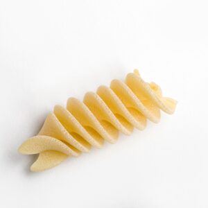Pasta fusilli oro Verrigni en crudo pieza individual trafilada en oro sobre fondo blanco