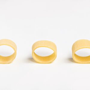 Pasta la calamarata oro Verrigni en crudo piezas alineadas sobre fondo blanco