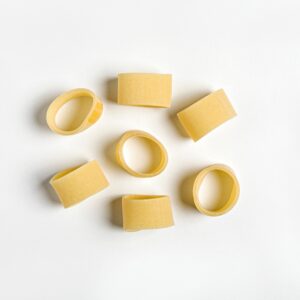 Pasta la calamarata oro Verrigni en crudo composición de varias piezas sobre fondo blanco