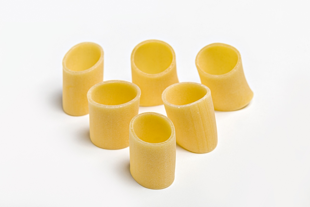 Mezzo Pacchero Oro Verrigni · vista superior | AGÁPICO Pasta mezzo pacchero oro Verrigni en crudo vista superior de piezas sobre fondo blanco