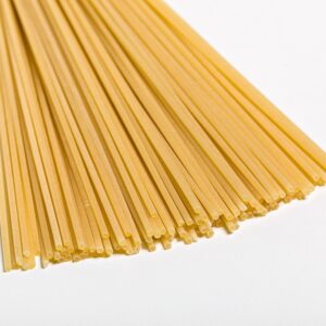 Pasta spagueti oro Verrigni en crudo detalle del corte y sección sobre fondo blanco