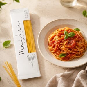 Spaghetti sin gluten Maidea servidos con salsa de tomate y albahaca junto a su envase original