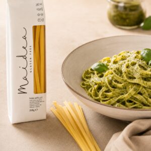 Tagliatelle sin gluten Maidea servidos con pesto, albahaca y queso junto a su envase original