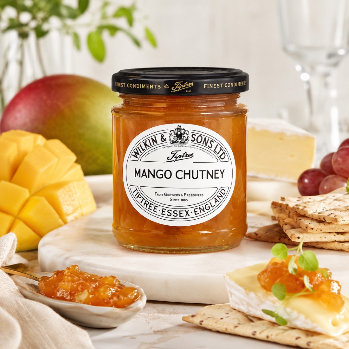 Chutney de Mango Tiptree con queso brie Chutney de mango Tiptree Wilkin & Sons con queso brie, crackers y mango fresco