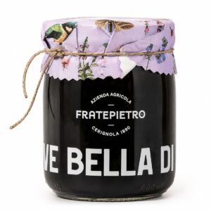 Aceitunas negras Bella di Cerignola Fratepietro en tarro de cristal con tapa decorativa sobre fondo blanco