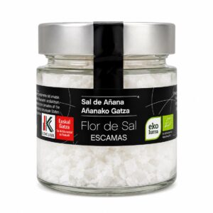 Flor de Sal en Escamas Sal de Añana ecológica en tarro de cristal sobre fondo blanco