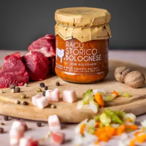 Salsa ragú boloñesa tradicional Alpe Magna con ingredientes frescos, carne y verduras, presentada en escena culinaria artesanal.