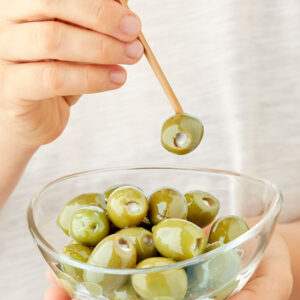 Aceitunas verdes rellenas de tomate y anchoa Oliveri Piemonte servidas como aperitivo