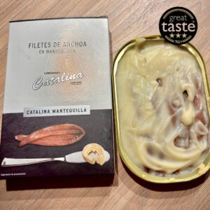 Anchoas de Santoña en mantequilla Conservas Catalina con lata abierta y estuche premiado Great Taste 2024.