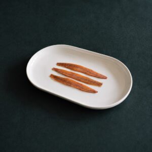 Anchoas del Cantábrico en aceite de oliva Conservas Catalina servidas en plato blanco