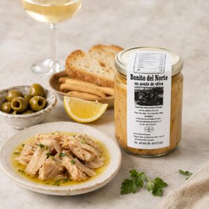 Bonito del Norte en Aceite de Oliva Conservas Lavín servido con aceitunas, limón, pan y vino blanco