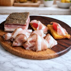 Pancetta de Colonnata Antica Larderia Mafalda cortada en lonchas sobre tabla de madera