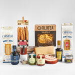 Cesta gourmet de pasta italiana con salsas, aceite y queso parmesano