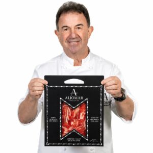 Chef sosteniendo Estuche Martín Berasategui Jamón de Bellota 100% Ibérico Aljomar Corte a Cuchillo 25 sobres