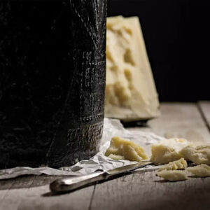 Detalle de queso Pecorino Romano DOP de oveja, curado, con textura granulosa y sabor intenso