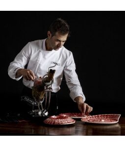 Maestro cortador realizando corte a cuchillo de jamón ibérico Aljomar