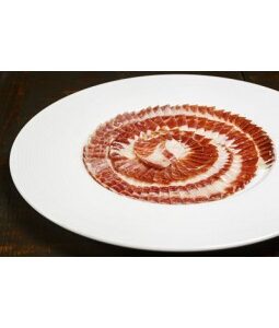 Jamón de bellota 100% ibérico cortado a cuchillo y presentado en plato gourmet