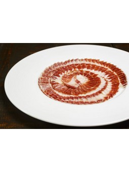 Jamón de Bellota 100% Ibérico – Corte a Cuchillo en Plato Jamón de bellota 100% ibérico cortado a cuchillo y presentado en plato gourmet
