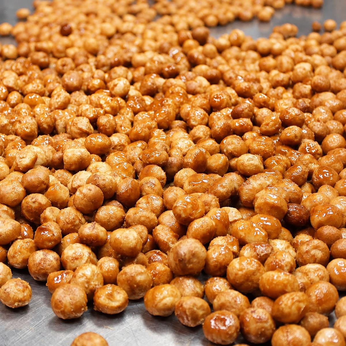Nueces de Macadamia con Chocolate Blanco BUBÓ Barcelona · 190 g · Detalle de Elaboración Nueces de macadamia BUBÓ Barcelona caramelizadas en proceso de elaboración