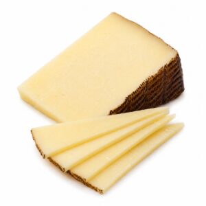 Queso Manchego mezcla semicurado Siete Coronas servido en lonchas finas junto a cuña sobre fondo blanco