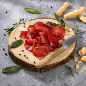 Bresaola Italiana Salumificio Squisito 200 g servida en tabla con cuchillo y grissini