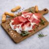 Culatello di Zibello DOP Salumificio Squisito 200 g servido en tabla con grissini, romero y pimienta