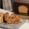 Panettone de chocolate artesanal con estuche y crema gourmet sobre mesa de mármol