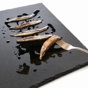 Anchoas del Cantábrico premium con piel Conservas Catalina servidas en pizarra