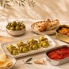 Aperitivo gourmet en casa con gildas, conservas, aceitunas, vermut, patatas fritas y crackers