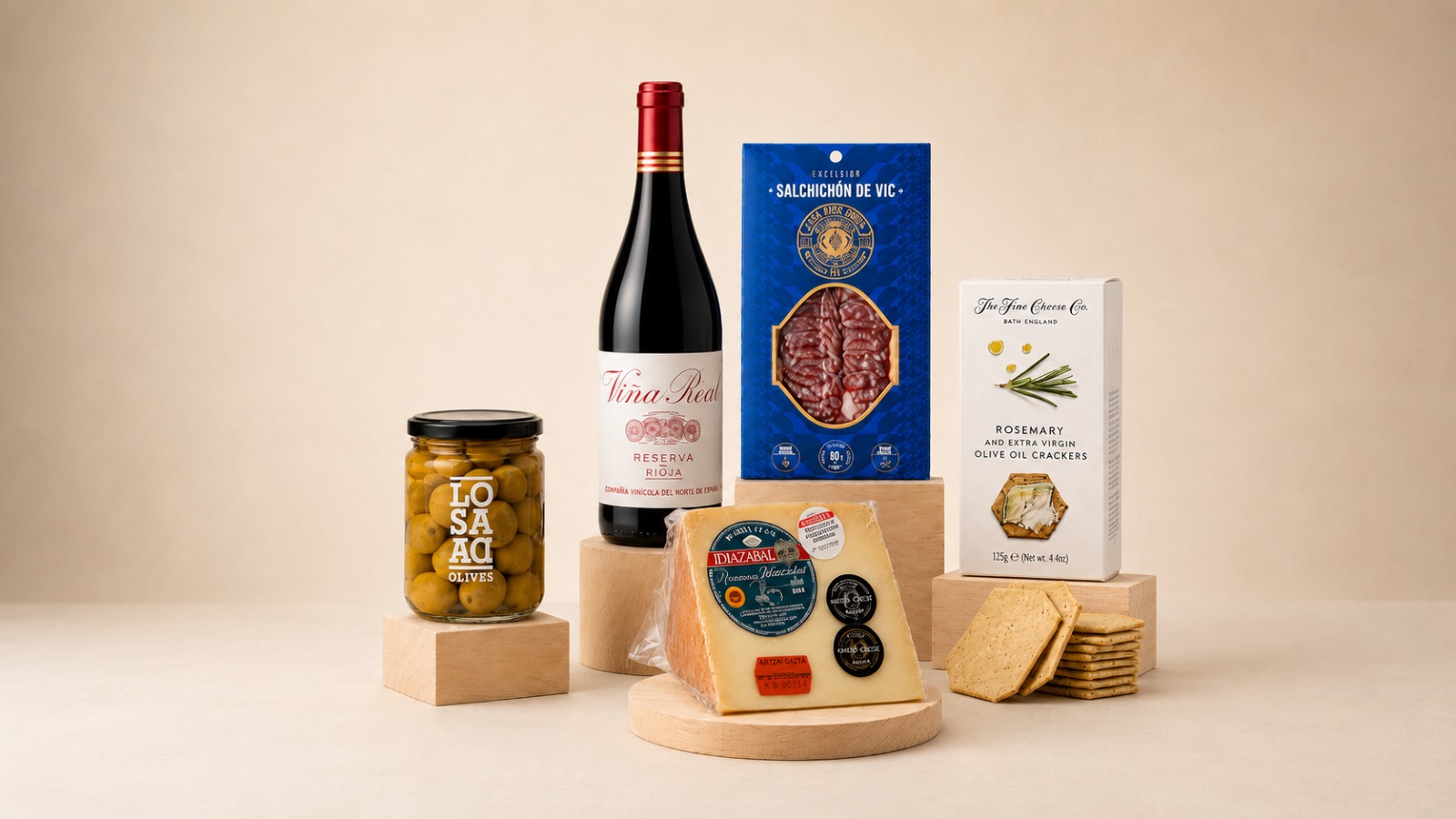 Selección gourmet corporativa con vino Rioja, queso Idiazábal, salchichón de Vic, aceitunas y crackers